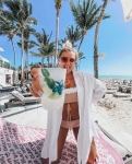 Beżowe bikini bandeau z kwiatami 3D na tle morza – luksusowa stylizacja wakacyjna